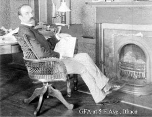 atkinson in front of fireplace with papers